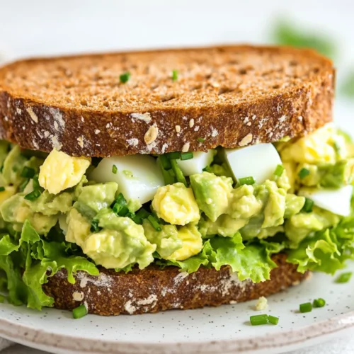 Avocado Egg Salad Sandwich: A Healthy, Protein-Packed Lunch Idea 2 Avocado Egg Salad Sandwich On A White Plate With Fresh Chives And Lettuce, Set Against A Neutral Background