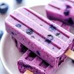 Blueberry Yogurt Pops On A White Plate With Fresh Blueberries And Honey Drizzle