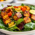 Citrus Lime Tofu Salad On A White Plate With Roasted Vegetables And Pumpkin Seeds, Garnished With Vinaigrette