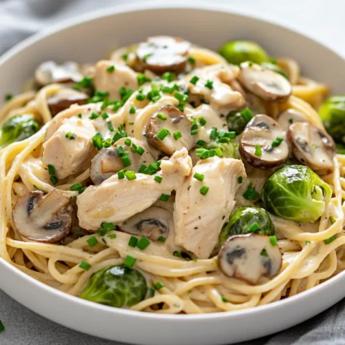 Creamy Chicken Pasta With Brussels Sprouts: A Healthy One-Pot Meal 2 Creamy Chicken Pasta With Brussels Sprouts Served In A White Bowl, Garnished With Fresh Chives And Mushrooms.
