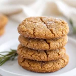 Golden Gluten-Free Gingersnaps With Crackled Tops On A White Plate, Lightly Sugared, And Garnished With Rosemary Sprigs.