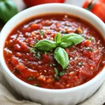 Bowl Of Healthy Homemade Spaghetti Sauce With Fresh Tomatoes, Garnished With Basil And Red Pepper Flakes On A Wooden Surface