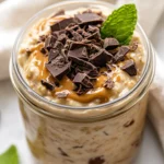 High-Protein Overnight Oats With Peanut Butter In A Glass Jar, Topped With Chocolate Shavings And Mint Leaves