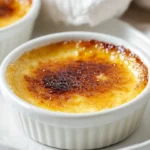 Keto Crème Brûlée Dessert In A Ramekin With A Golden Caramelized Crust And Vanilla Custard, On A Clean White Plate.