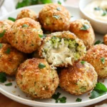 Crispy Low-Carb Broccoli Croquettes With A Golden Almond Coating On A White Plate, Garnished With Parsley And Aioli Dip.