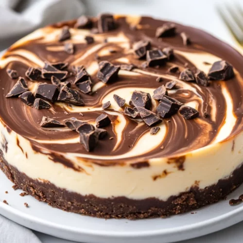 Low-Carb Chocolate Swirl Cheesecake: A Guilt-Free Dessert Indulgence 2 Low-Carb Chocolate Swirl Cheesecake On A White Plate, Garnished With Chocolate Shavings And Nuts, Velvety And Creamy Texture