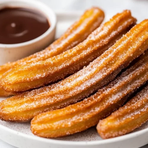 Golden Crispy Air Fryer Churros On A White Plate With Cinnamon Sugar, Served With A Chocolate Sauce For Dipping