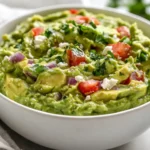 Bowl Of Avocado Feta Dip With Fresh Parsley Garnish And Vibrant Tomato Chunks