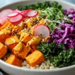 Colorful Best Buddha Bowl With Roasted Sweet Potatoes, Kale, And Turmeric Tahini Sauce, Garnished With Sesame Seeds