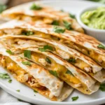 Crispy Chicken Quesadillas On A White Plate With Guacamole And Salsa, Garnished With Cilantro