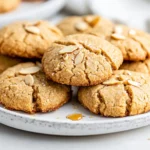 Plate Of Easy Almond Flour Cookies Drizzled With Maple Syrup, Garnished With Almond Slivers