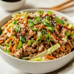 Bowl Of Egg Roll In A Bowl Topped With Green Onions And Sesame Seeds On A Light Background
