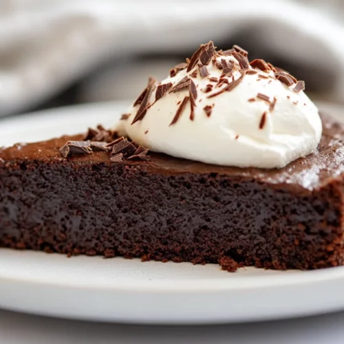 Flourless Chocolate Cake: The Best Gluten-Free Dessert Recipe 2 Flourless Chocolate Cake On A White Plate Topped With Whipped Cream And Chocolate Shavings
