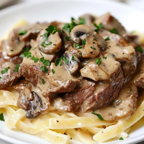 Delicious Gluten-Free Beef Stroganoff Over Gluten-Free Pasta, Garnished With Parsley On A White Plate
