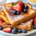 Delicious Gluten Free French Toast Stacked On A White Plate, Garnished With Fresh Strawberries And Powdered Sugar