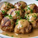 Gluten Free Swedish Meatballs In Creamy Gravy On A White Plate, Garnished With Parsley And Invitingly Warm