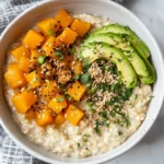 Creamy Healthy Oat Porridge In A White Bowl Topped With Butternut Squash, Avocado, And Toasted Pepitas