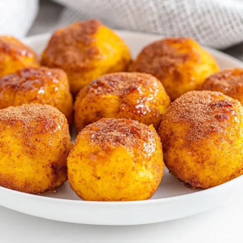 Plate Of Healthy Pumpkin Bites Drizzled With Maple Syrup And Garnished With Cinnamon Sprinkles