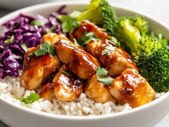 Delicious Hot Honey Chicken Bowl Filled With Chicken, Rice, Roasted Broccoli, And Purple Cabbage Garnished With Parsley