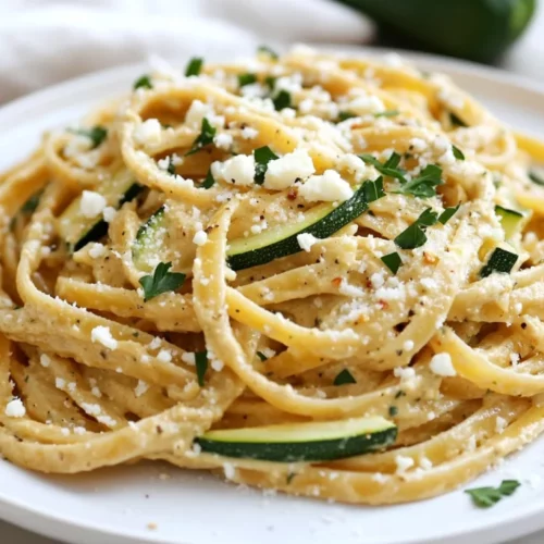 Hummus Linguini With Zucchini Served On A White Plate, Garnished With Feta Cheese And Fresh Parsley