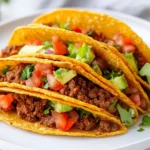 Plate Of Keto Beef Tacos In Crispy Cheese Shells Topped With Avocado, Lettuce, And Tomatoes