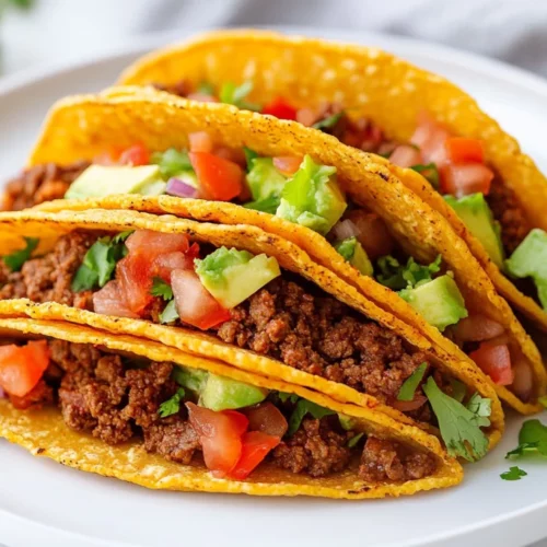 Delicious Keto Beef Tacos With Baked Cheese Shells 2 Plate Of Keto Beef Tacos In Crispy Cheese Shells Topped With Avocado, Lettuce, And Tomatoes