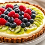 Colorful No-Bake Greek Yogurt Tart Topped With Fresh Fruit On A White Ceramic Plate
