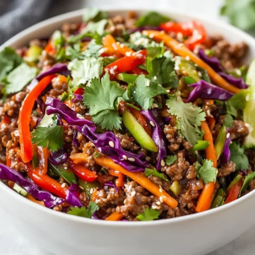 Sesame Ginger Ground Beef Slaw - A Healthy, Flavor-Packed Recipe 2 Colorful Sesame Ginger Ground Beef Slaw In A White Bowl Garnished With Cilantro And Lime Wedges