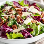 Vibrant Winter Green Salad In A White Bowl, Topped With Aged Gouda And Candied Pecans On A Neutral Backdrop