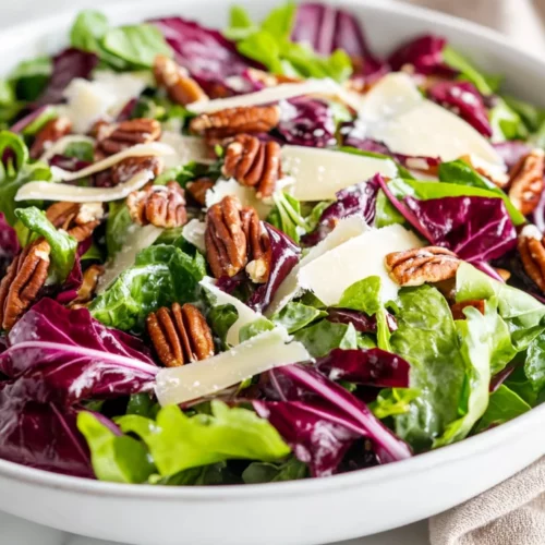 Vibrant Winter Green Salad In A White Bowl, Topped With Aged Gouda And Candied Pecans On A Neutral Backdrop