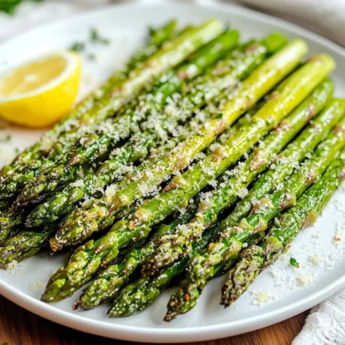 Crispy Air Fryer Asparagus: Healthy, Easy, And Delicious 2 Crispy Air Fryer Asparagus On A White Plate, Garnished With Parmesan And Lemon, Showcasing Crunchy Tips