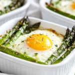 Baked Asparagus With Eggs Served In White Dishes, Topped With Parmesan Cheese And Fresh Herbs