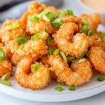 Crispy Bang Bang Shrimp Air Fryer On A White Plate Garnished With Sliced Green Onions And Shredded Romaine
