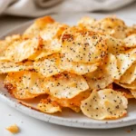 Crispy Cottage Cheese Chips On A White Plate, Topped With Everything Bagel Seasoning And A Warm Background