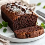 Delicious Double Chocolate Zucchini Bread Slices On A White Plate Garnished With Powdered Sugar And Fresh Mint