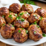 Juicy Easy Baked Meatballs On A White Plate Garnished With Fresh Parsley And Set On A Light Wooden Table