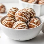 Chewy Gingerbread Protein Balls Drizzled With White Chocolate In A White Bowl, Showcasing A Rustic Texture