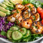 Vibrant Grilled Shrimp Salad On A White Plate With Fresh Greens, Avocado, And A Drizzle Of Lemon Vinaigrette