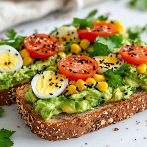 Guacamole Breakfast Toast: A Quick, Healthy Start To Your Day 2 Guacamole Breakfast Toast On A White Plate Topped With Charred Corn, Hard-Boiled Eggs, And Parsley