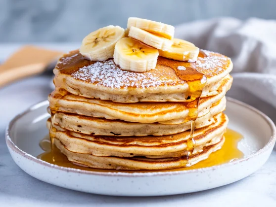 Healthy Banana Pancakes: Fluffy, Nutritious, And Easy To Make 2 Fluffy Healthy Banana Pancakes Drizzled With Maple Syrup And Topped With Blueberries On A White Plate