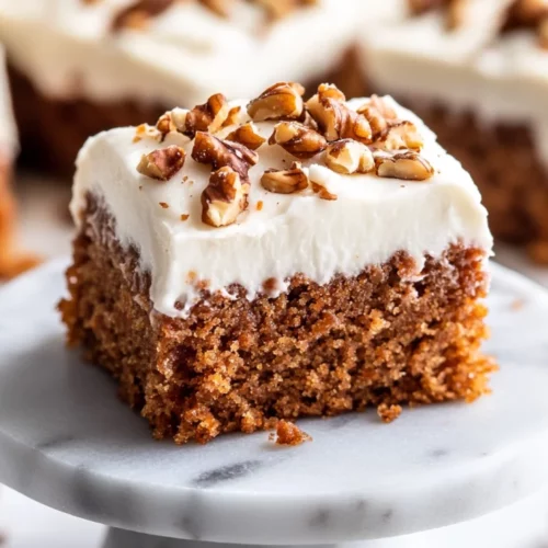 Healthy Carrot Cake Bars Topped With Cream Cheese Frosting And Walnuts On A White Plate