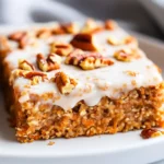 Baked Healthy Carrot Cake Oatmeal Squares Topped With Cream Cheese Glaze And Pecans On A White Plate