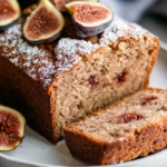 Healthy Fig Bread Loaf On A White Plate, Topped With Fig Slices And A Dusting Of Powdered Sugar
