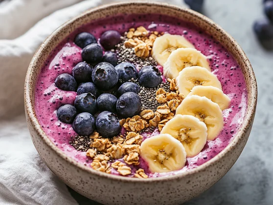 Bowl Of Healthy Smoothie Bowl Topped With Banana, Berries, Granola, And Chia Seeds, Served On A Neutral Background.