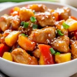 Bowl Of Healthy Sweet And Sour Chicken With Vibrant Vegetables And Garnished With Green Onions