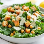 Vibrant Kale Caesar Salad In A White Bowl Topped With Croutons And Shaved Parmesan