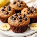 Delicious Paleo Banana Muffins On A White Plate, Garnished With Banana Slices And Chocolate Chips