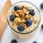 Bowl Of Princess Diana Overnight Oats Topped With Blueberries And Walnuts, Served In A Clear Jar
