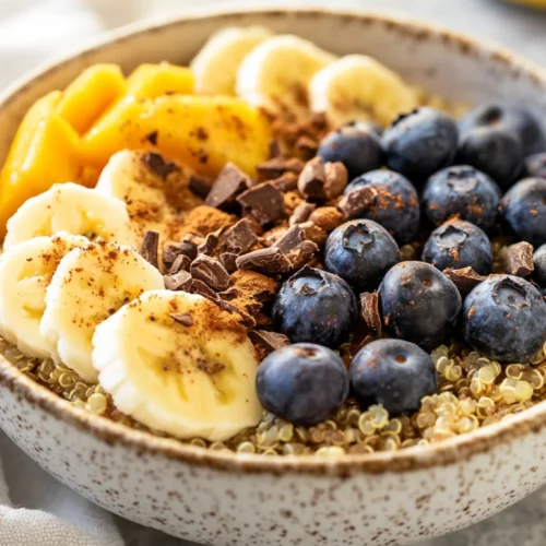 Quinoa Breakfast Bowl: A Healthy Start To Your Morning 2 Bowl Of Quinoa Breakfast Bowl Topped With Fresh Fruits, Cacao Nibs, And Maple Syrup On A Wooden Surface