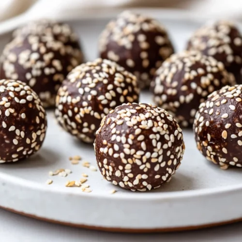 Tahini Chocolate Balls - Easy, No-Bake Healthy Treats 2 Plate Of Tahini Chocolate Balls Coated In Sesame Seeds, Set Against A Neutral Background